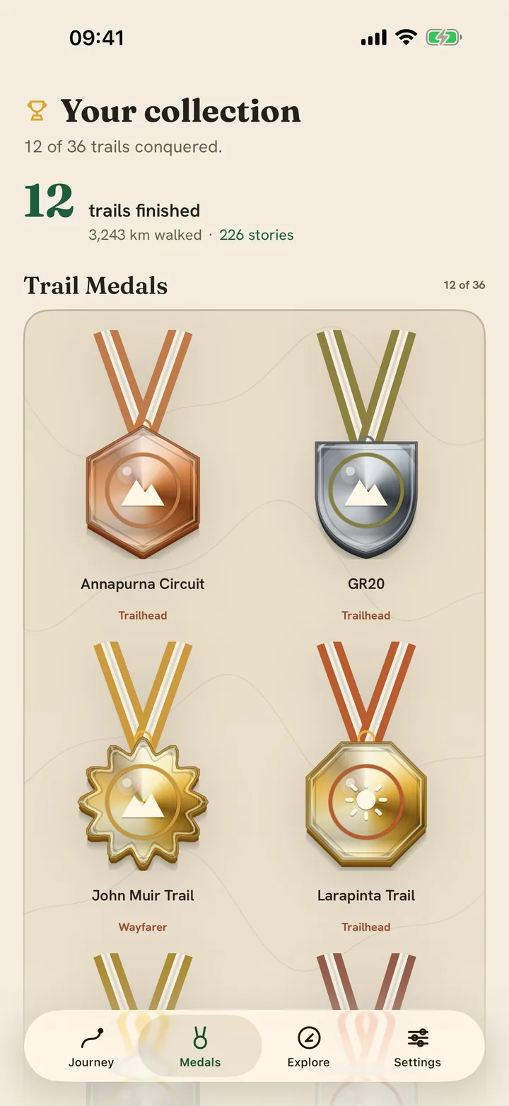 The Watch Walks medal wall: the earned medals lead it, die-cut on ribbons and struck in bronze, silver and gold — the Annapurna Circuit, the GR20, the John Muir Trail and the Larapinta Trail — each with the prestige the walker earned on it