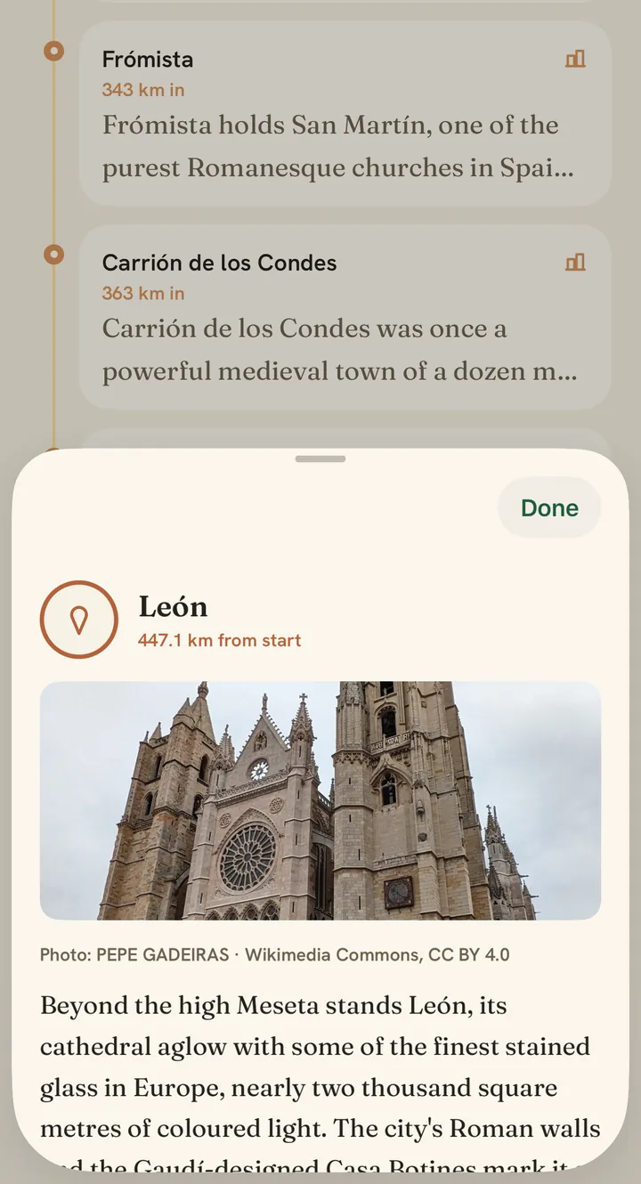 A story card open in the Watch Walks app: León, 447 km along the Camino, with a photograph of its Gothic cathedral, the photographer's credit, and a few lines about the stained glass and the Roman walls